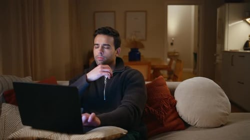 Man Works On Laptop At Night At Home