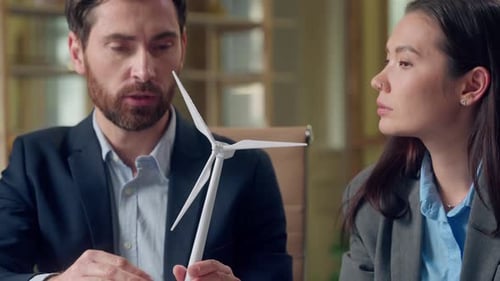 Multiethnic Business Woman Man Discussing Alternative Energy Windmill Model at Office Caucasian