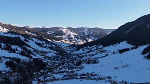 Aerial View of Saalbach Alpine Village in Austrian Alps During Sunny Winter Sunrise in Saalbach