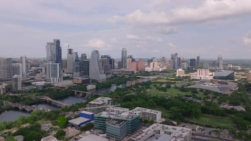 Aerial View of Austin Skyline with Skyscrapers Green Trees and River Under a Partly Cloudy Sky Urban