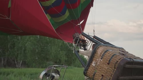 Pilot Igniting Burner to Inflate Hot Air Balloon Envelope in Field