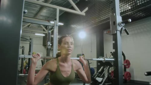 Young Athletic Woman Performing Barbell Squats in Gym