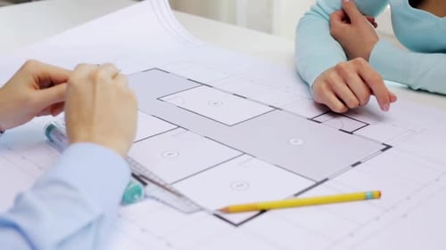 Architects discussing blueprint for new house construction real estate project