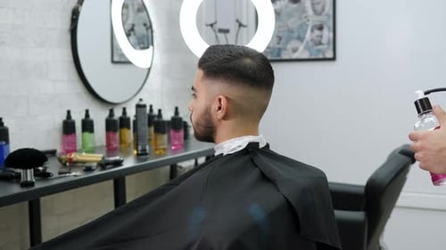 Barber Sprays Client's Hair in Barber Shop