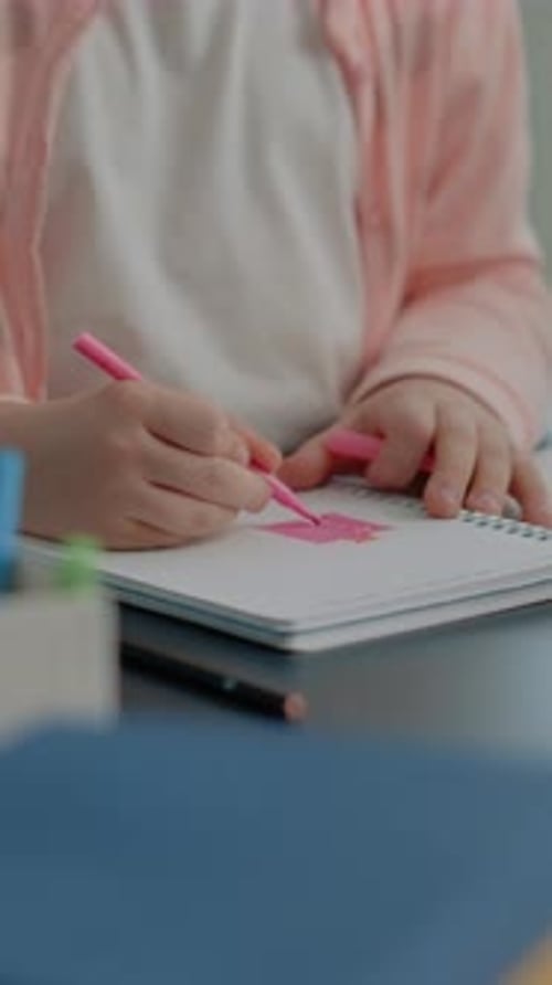 Vertical Video Close Up of Young Child Using Colorful Pencils on Notebook