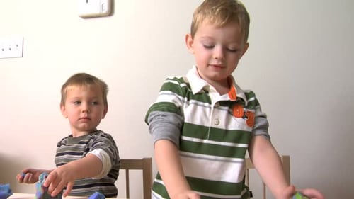 Boys playing with colorful modeling clay at home