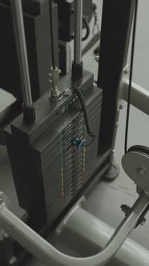 Gym weight stack close up with cable system vertical