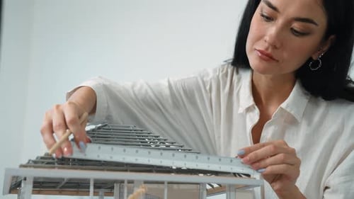 Professional architect using ruler measuring model roof length. Immaculate.