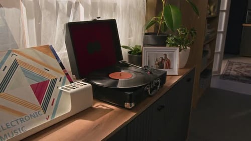 Retro Record Player on Cabinet with Plants and Album