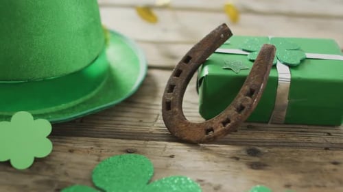 Shamrocks and green hat with horseshoe over coins with copy space on wooden table
