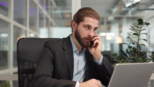 Programador concordando com o interlocutor enquanto fala no smartphone no gabinete