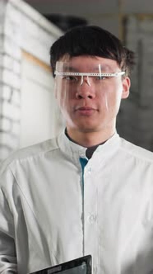 Technicians Holding Tablets and Adjusting Safety Glasses in Automotive Workshop