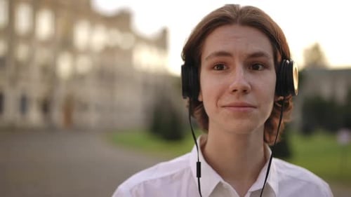 Young Adult Listens to Music with Headphones