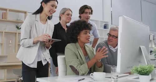 Diverse Team Collaborating on Computer Project in Office