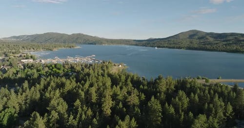 a body of water with trees and mountains in the background