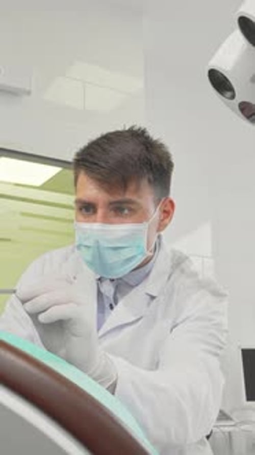 Dentiste masculin dévoué examinant les dents d'une petite fille dans une clinique lumineuse