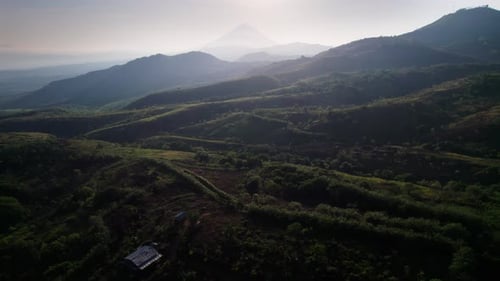 Epic Aerial Sunrise Over Hazy Hills with Volcano Peak Silhouette
