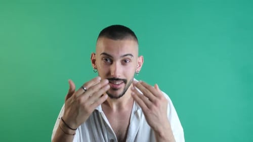 Man Inviting Viewer Closer on Green Background