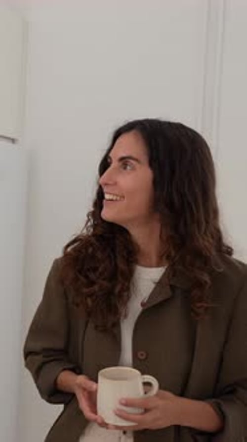 Woman Holding Mug and Talking Indoors