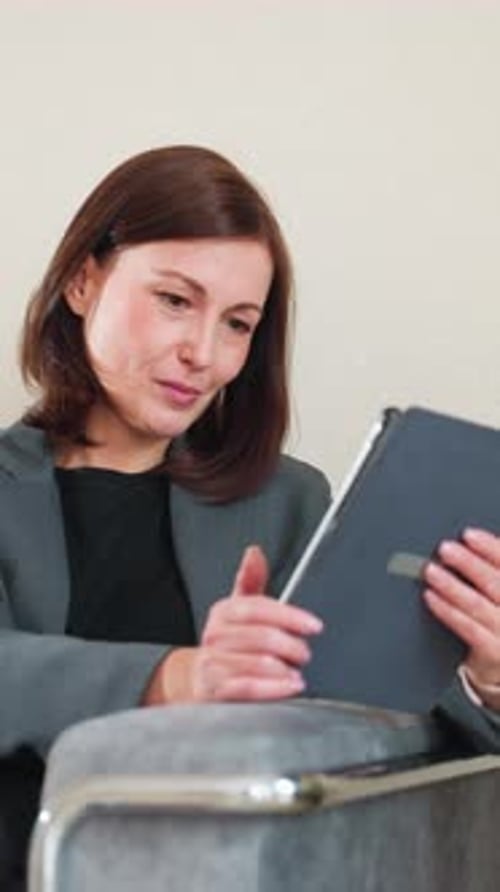 Businesswoman Using Tablet on Couch in Relaxed Office Environment