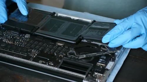 Gloved Hands Repairing Laptop Computer