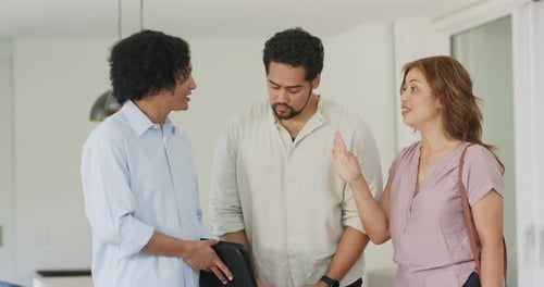 Agent africain et couple, femme faisant des gestes, agent montrant une boîte noire pendant que le couple passe en revue