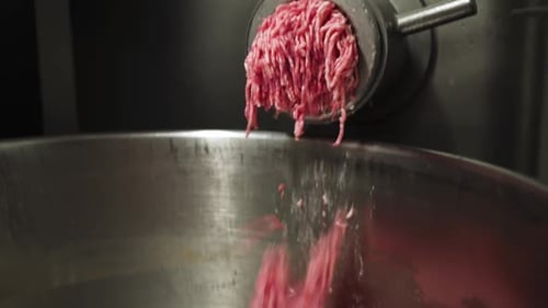 Minced meat falling out of industrial close up view