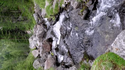 Ein Gebirgsbach in den Alpen fließt entlang eines steinigen Flussbetts hinunter