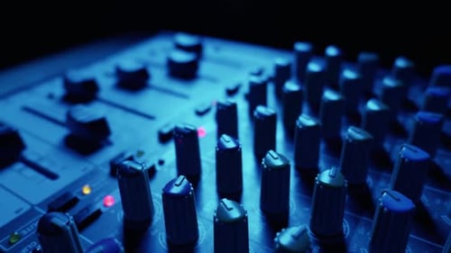 Audio Mixing Console Knobs and Faders in Blue Studio Lighting