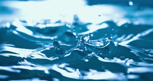 Blue Water Droplets Creating Ripples and Splashes