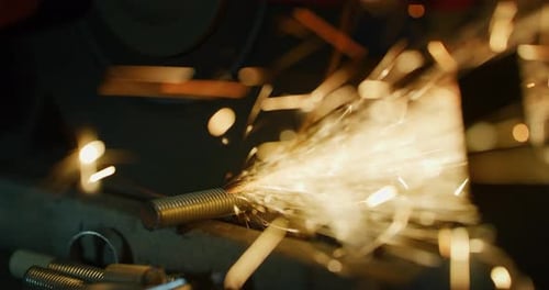 Industrial worker grinding metal with a lot of sharp sparks (extra macro tool close up)