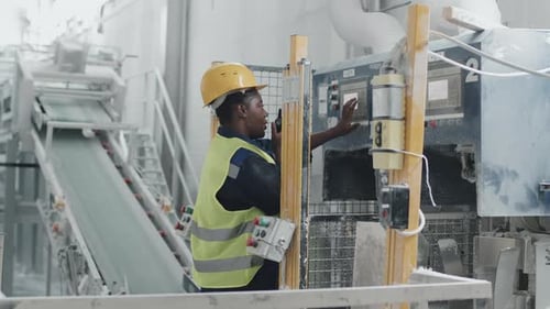 Female Factory Worker Changing Machine Settings