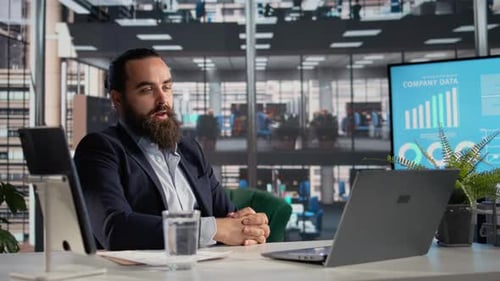 Businessman Discusses Company Data via Laptop Video Call
