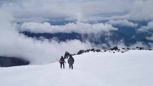 Mountain Climbers is Walking on the Ridge of the Snowy Mountain Summit in Winter