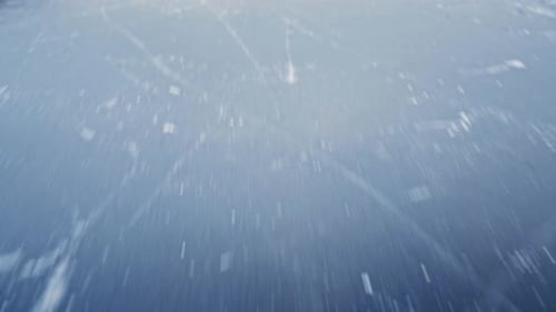 Die Kamera fliegt über einen gefrorenen See und enthüllt eine wunderschöne Landschaft mit schneebedeckten Bergen und Wäldern.