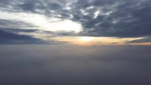 Aerial View of Sunrise Above Fluffy Clouds