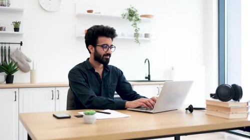 Young Man Working at Home on Laptop