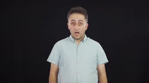 Man Expresses Surprise on Black Background