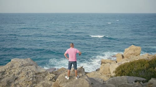 A Man Came on Holiday to the Sea Standing on a Rock and Enjoying the Seascape