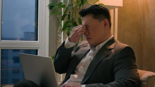 Man Working on Laptop Indoors at Night