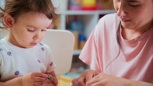 Child and Adult Playing with Modeling Clay at Home