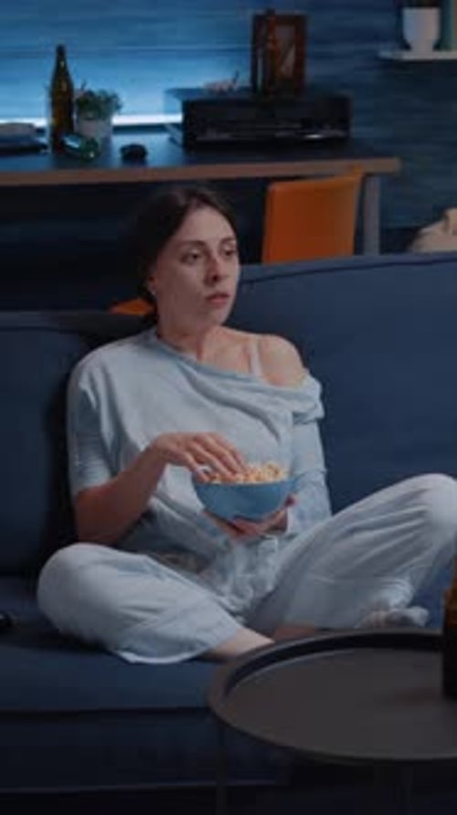 Vertical Video Focused Young Woman Paying Attention to Horror Film Eating Popcorn
