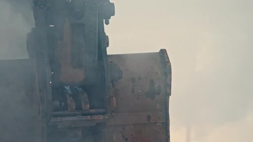 Excavator Dumping Dirt in Dusty Environment