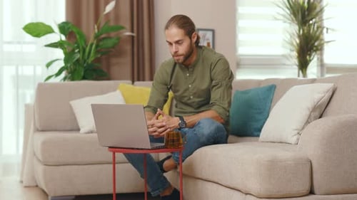 Smiling Man Having a Video Call on Laptop at Home
