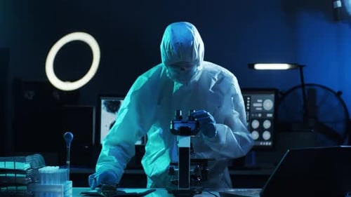 Scientist Works With Microscope in Lab at Night