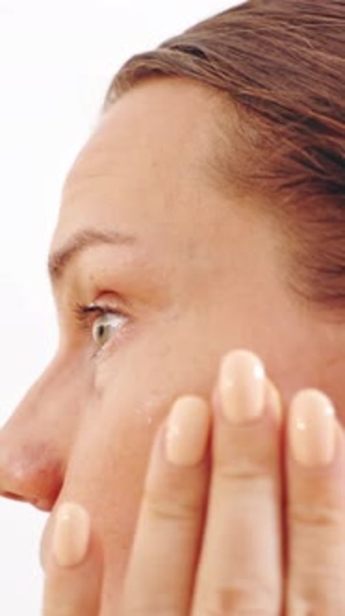 Woman Applies Cosmetic Product to Face, Close Up