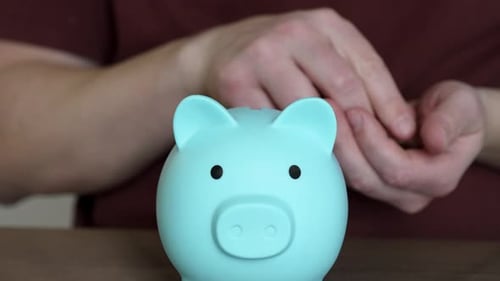 Geld sparen mit einem Sparschwein in einer häuslichen Umgebung