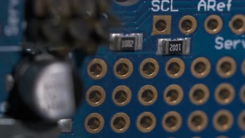 Vue rapprochée des ports et des condensateurs d'une carte de circuit électronique.