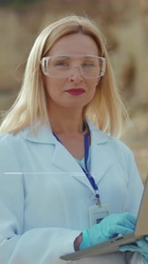 Woman Typing on Laptop Wearing Lab Coat