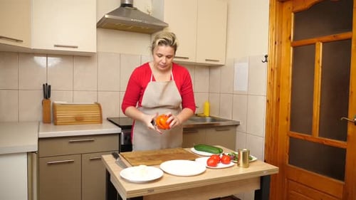Woman Prepares Vegetables in Bright Kitchen